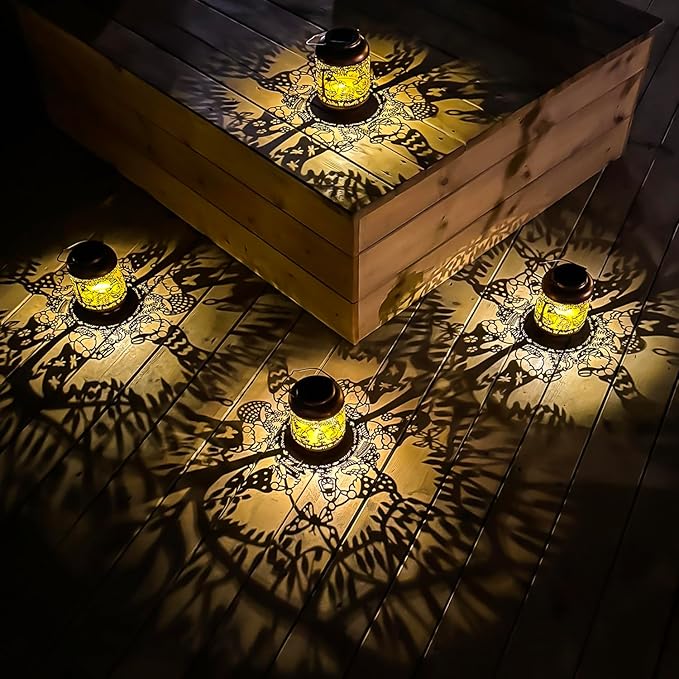 Set of four copper solar lanterns with glowing gnome cutout designs on table