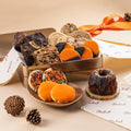 Assorted autumn gift tin with cookies and truffles, including orange slices and dark pastries