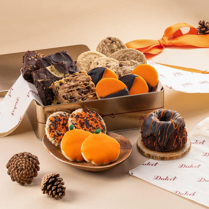 Assorted autumn gift tin with cookies and truffles, including orange slices and dark pastries