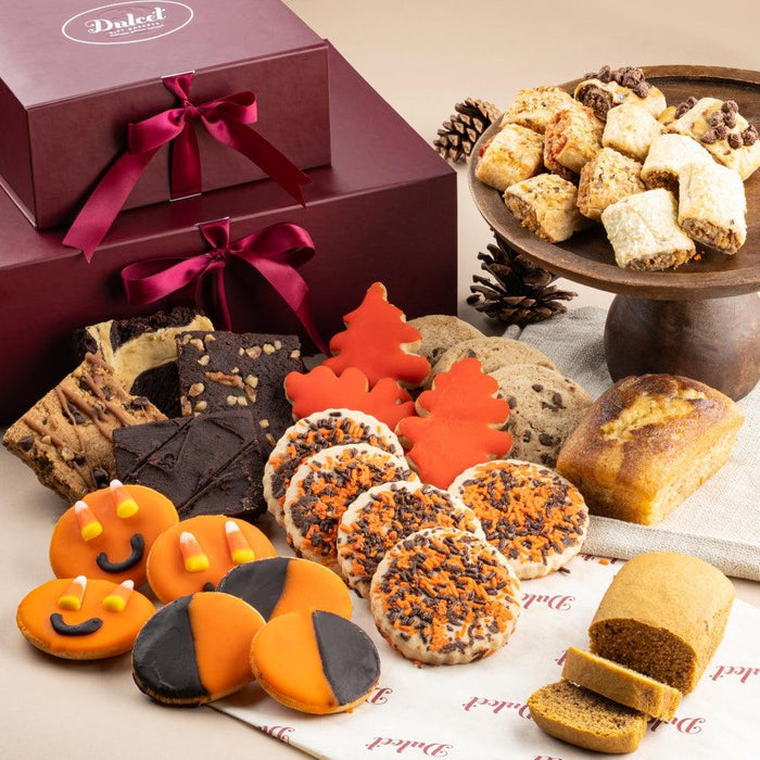 Assorted Halloween cookies on a tray beside stacked gift boxes with pink bows
