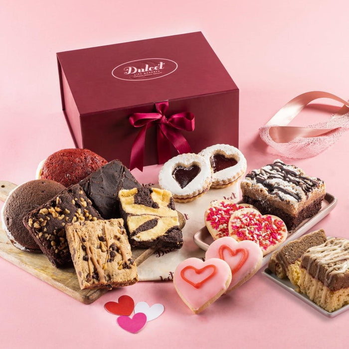 Valentine gift box with ribbon and assorted cookies and brownies on a serving tray