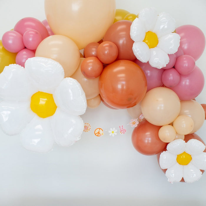 Balloon garland with white daisies and pink, peach, orange, and beige balloons
