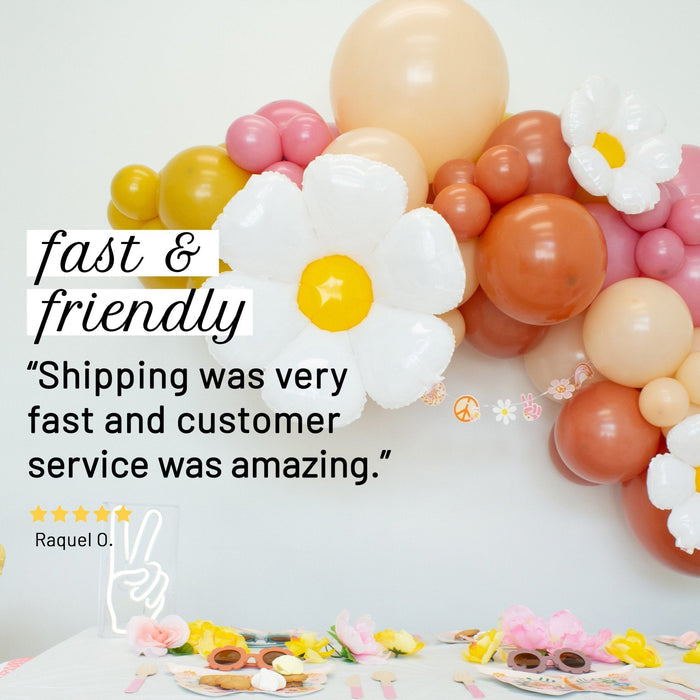 Balloon garland with large white daisy balloons and peach, pink, and orange clusters
