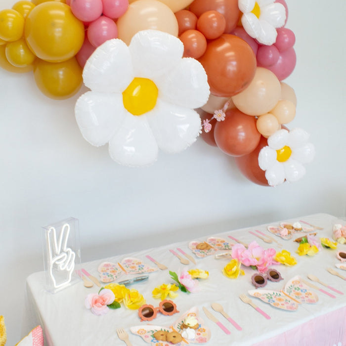 Close-up of balloon garland with a white daisy balloon and pastel orange, pink, and cream