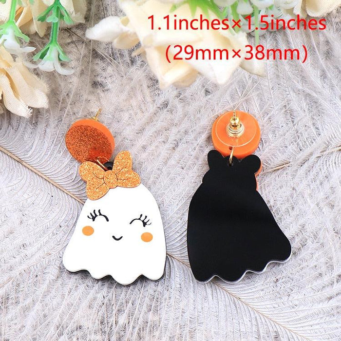 Ghost drop earrings: one orange glitter on white face, one black face with orange glitter accents