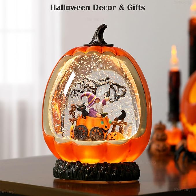 Orange pumpkin-shaped snow globe with swirling glitter and Halloween figurine scene