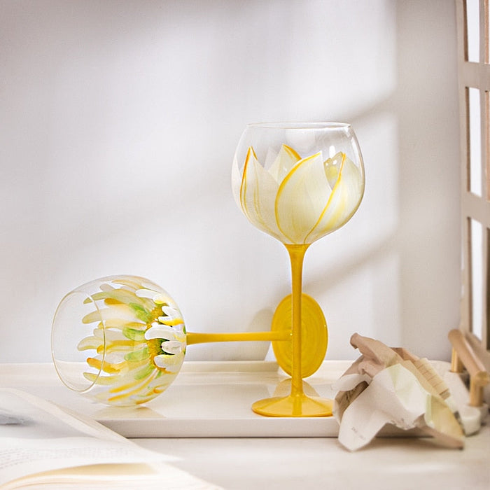Flower-pattern stemmed glass with yellow stem and white petal design; another bowl visible