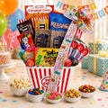 Movie night gift basket with striped popcorn container, candy assortments, and snack bowls