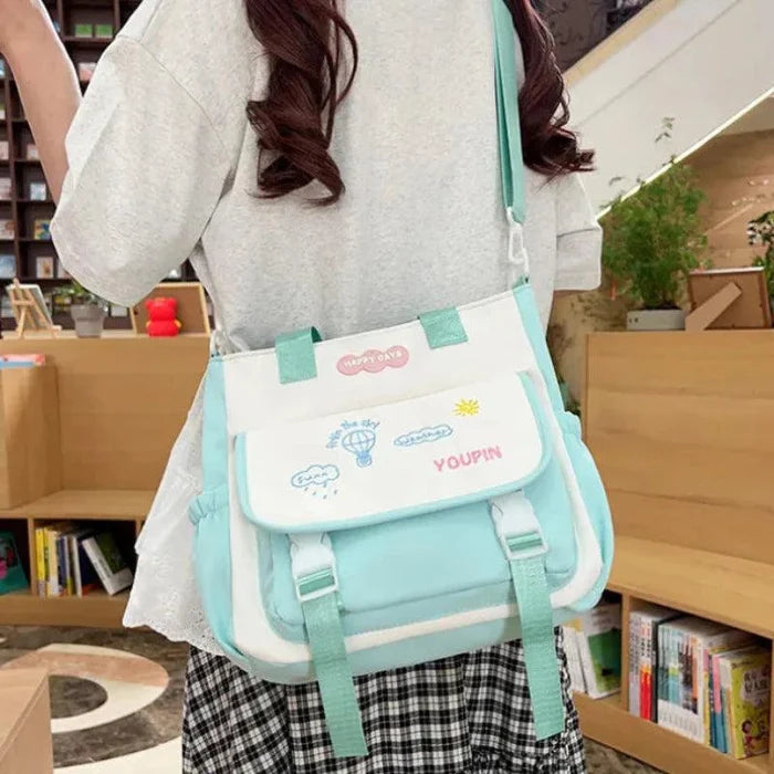 Teal and white cartoon backpack with front flap pocket and adjustable shoulder straps.
