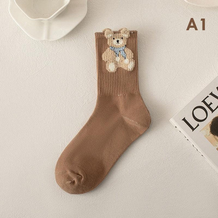 Brown socks with a cartoon teddy bear face stitched on the cuff and upper shaft.