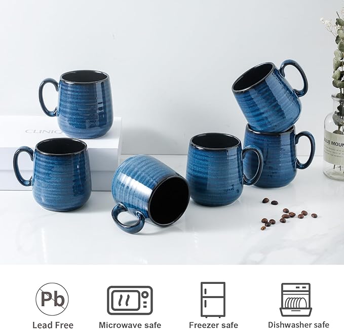 Blue ceramic coffee cups with black interiors, angled views, each with side handle