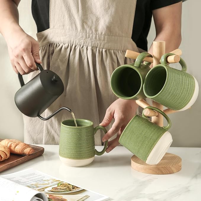 Green ceramic coffee mugs set of 4 with curved handles, one mug being poured