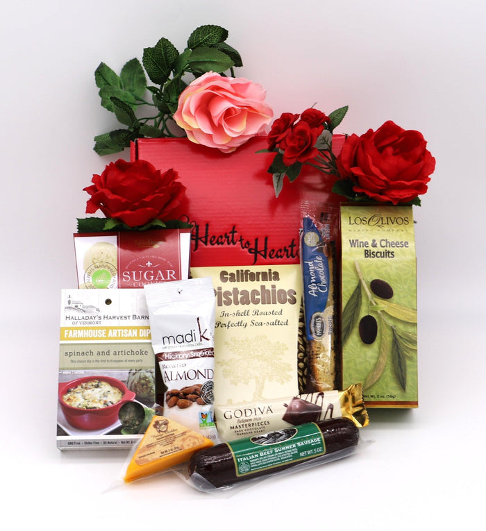 Red gift box filled with snack packages and red and pink roses, mint leaves