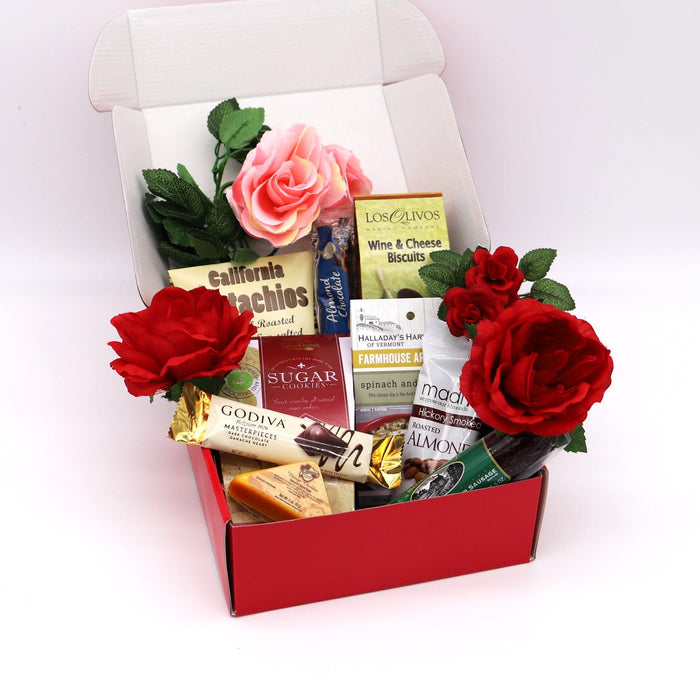 Open red gift box with roses and snack packages, gift basket arrangement