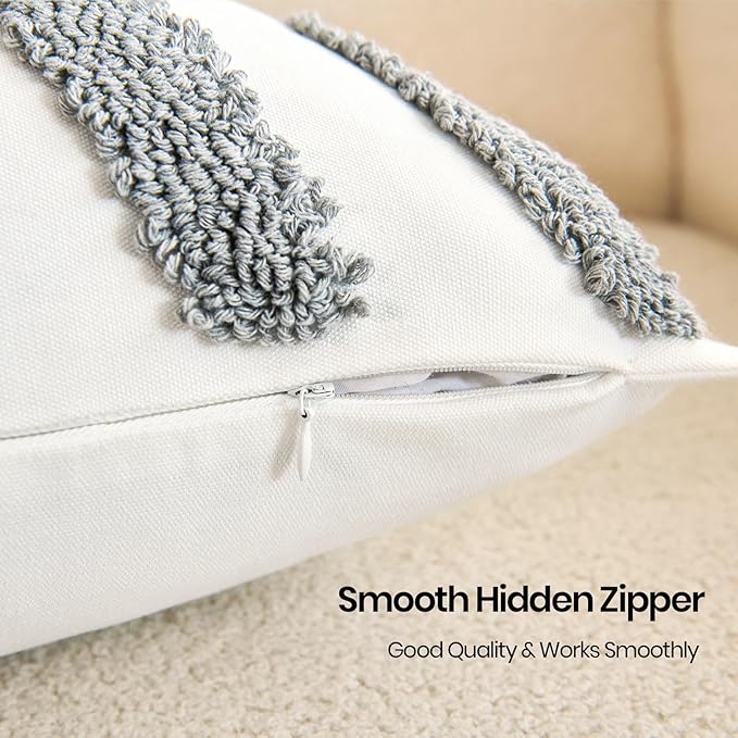 Close-up of white pillow cover with gray twisted fringe trim and tufted texture