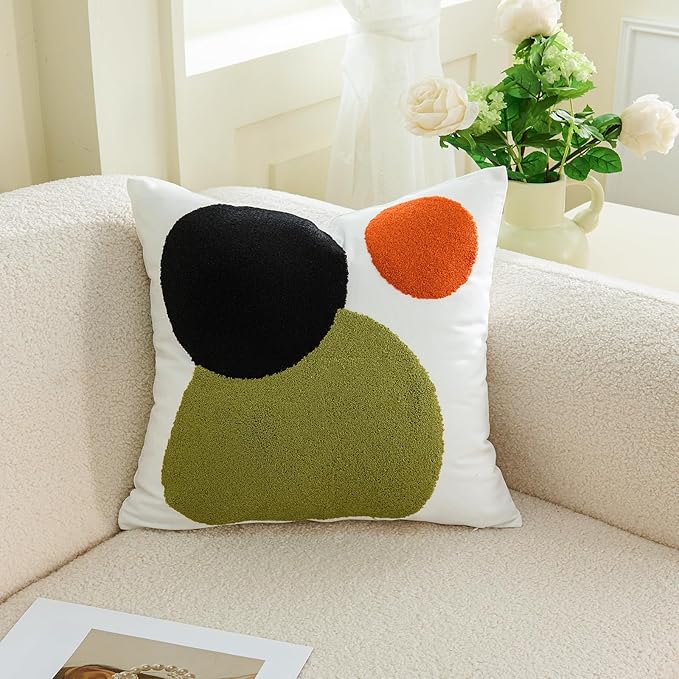 Tufted boho pillow cover with black, olive-green, and orange dot circles on a white background