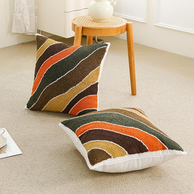 Set of two tufted pillow covers with curved striped pattern in dark green, orange, and tan