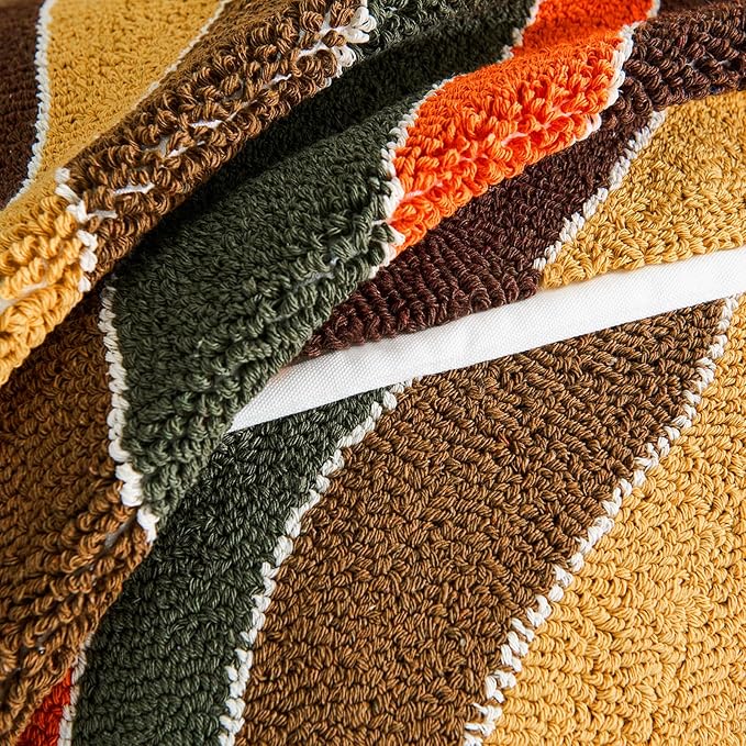 Tufted stripe pillow cover fabric close-up with looped yarn in green, brown, orange, tan