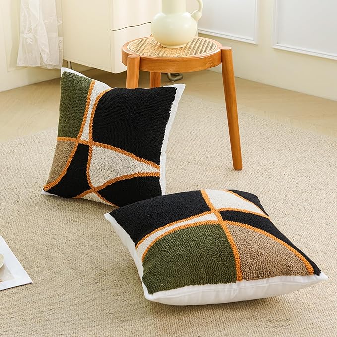 Tufted square pillow covers on floor and chair: green/black/tan cross with orange trim