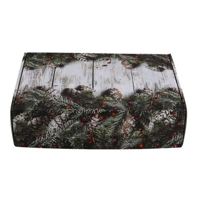Decorated holiday gift box lid with pine branches and red berry accents