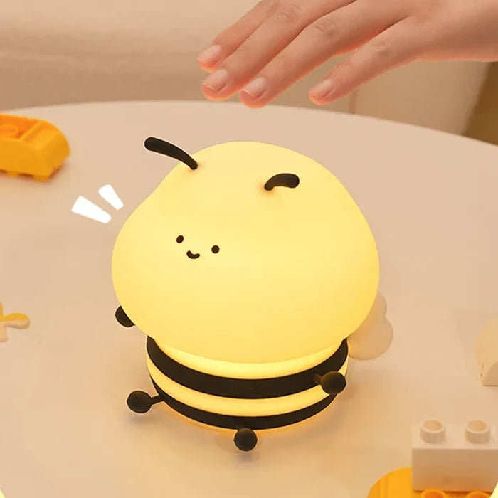 Honey bee night light with yellow glowing body, smiling face, and three stacked black bands