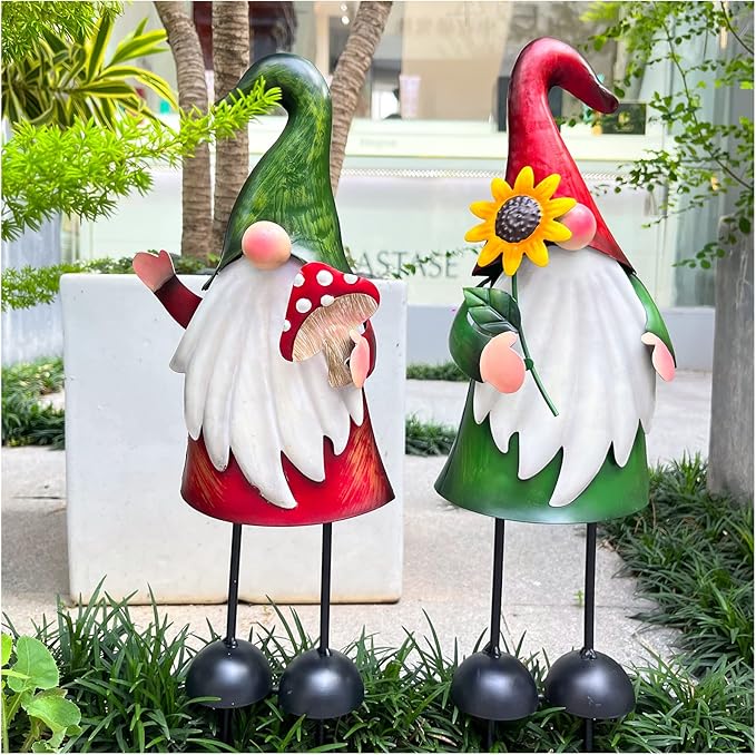 Pair of outdoor metal gnome figurines with white beard, flower accents, black stake legs