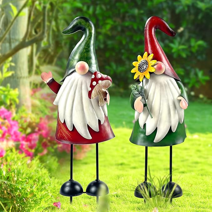 Two garden gnome stakes with green and red cone hats, white feathers, flower decorations