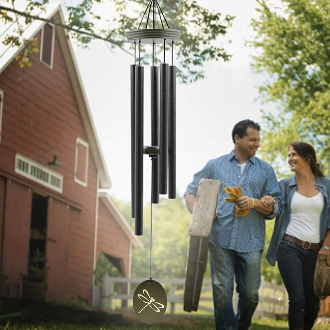 Outdoor wind chime with dark metal tubes and a green dragonfly oval hanging charm