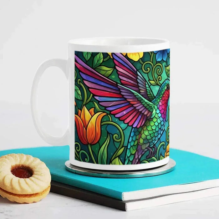 White ceramic mug with hummingbird stained-glass artwork on the front panel
