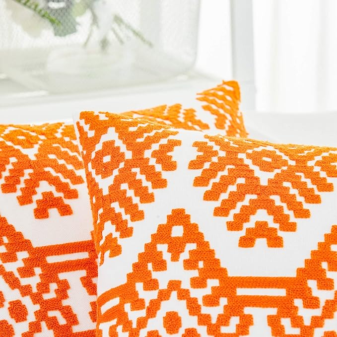 Orange embroidered throw pillow cover close-up with white diamond pattern