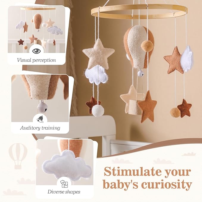 Baby mobile with dangling hot air balloon and star shapes over a crib canopy