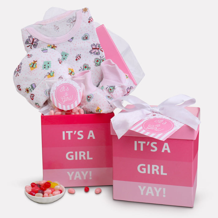 New baby gift basket with pink "It's a Girl" box, butterfly onesie, and candy pieces