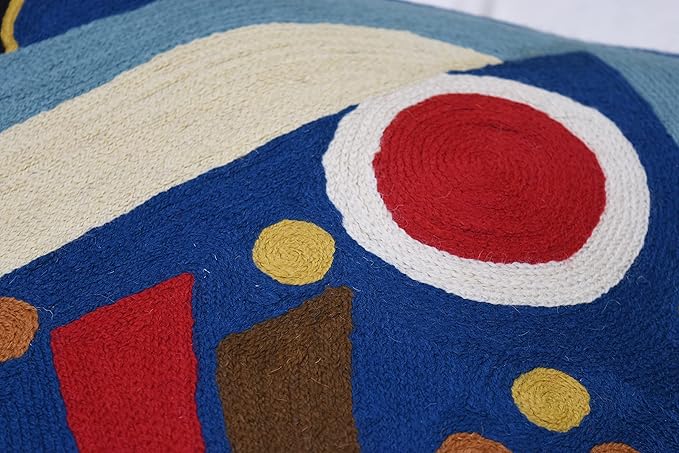 Close-up of blue abstract pillow cover with large red circle and small yellow dots