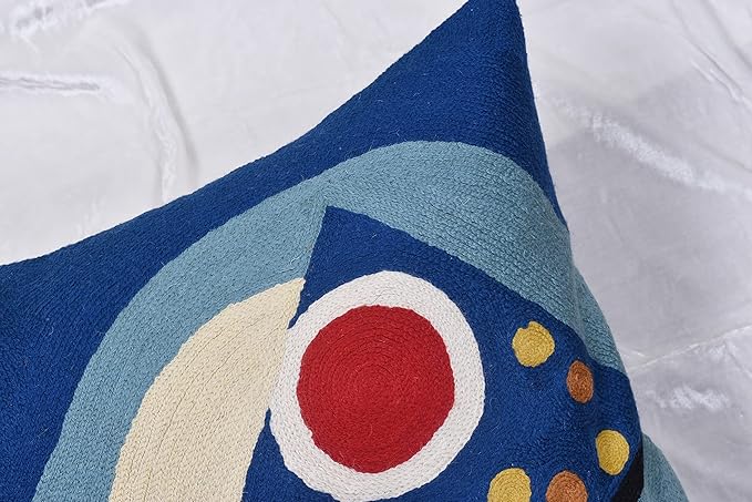 Close-up of blue abstract pillow cover with cream arch and red circle detail