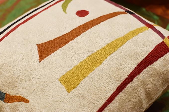 Cream pillow cover close-up with red border and multicolor geometric stripe lines