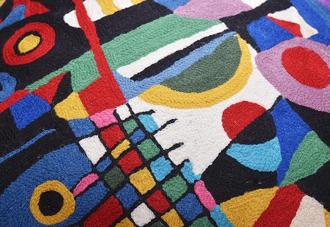 Black abstract embroidered pillow cover close-up with colorful lines, circles and grid motifs.