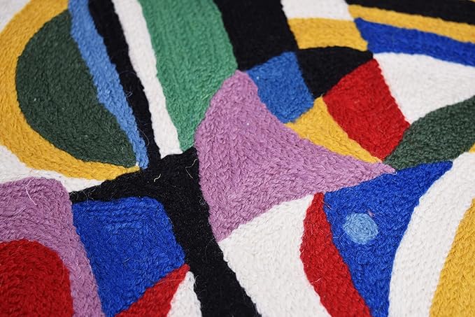 Black abstract embroidered pillow cover close-up with purple and blue curved geometric forms.