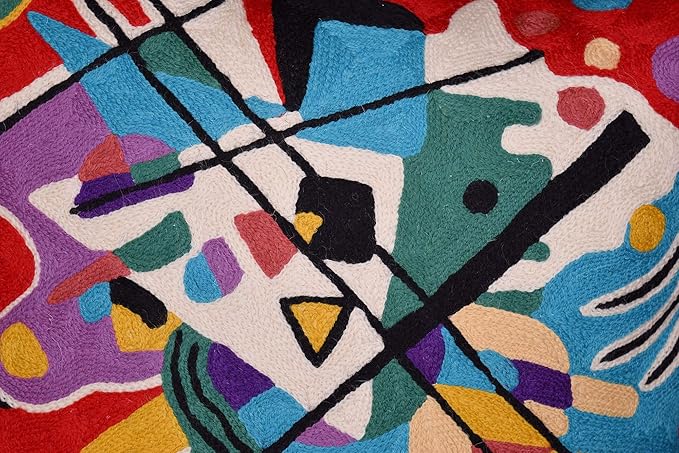 Red abstract pillow cover close-up with geometric forms in blue, teal, purple, yellow