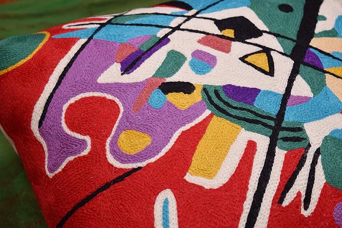 Red abstract pillow cover close-up corner with colorful blocks, dots, and black lines