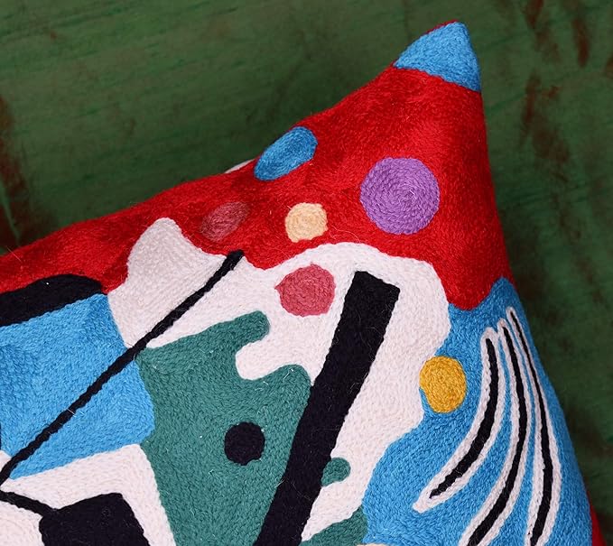 Red abstract pillow cover corner detail with blue, teal, and purple shapes