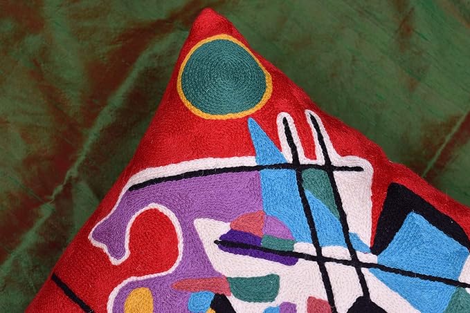 Red abstract pillow cover corner with green circle, purple shapes, and black lines
