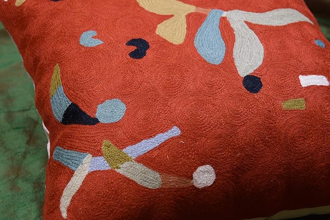 Orange abstract pillow cover corner with blue and white curving lines and dots