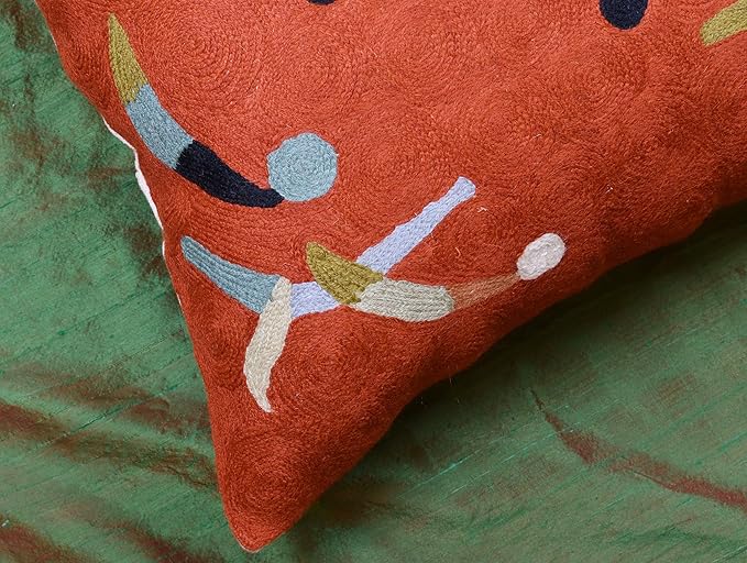 Orange abstract pillow cover corner with blue, white and yellow curved accents