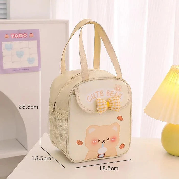 Cream insulated animal lunch bag with bow front pocket and bear illustration, size diagram shown