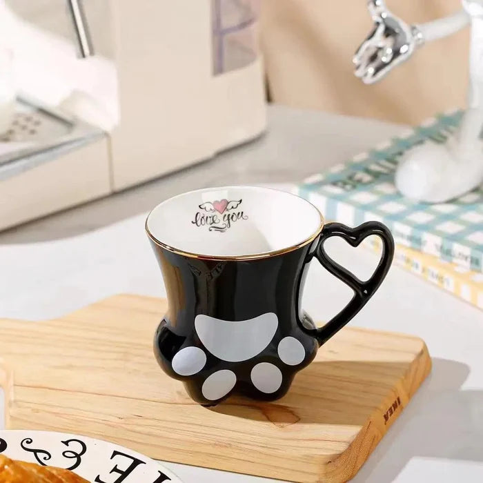 Black cat paw mug with heart handle and paw pad design on wooden board