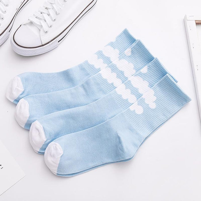 Light blue ankle socks laid flat, white cloud motifs across the leg and ribbed cuff