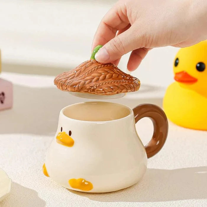 Duck-shaped ceramic mug with brown textured lid, orange beak, and side handle