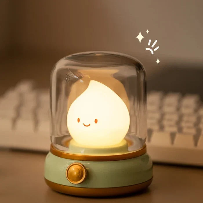 Green flame night light with smiling teardrop bulb under clear glass dome