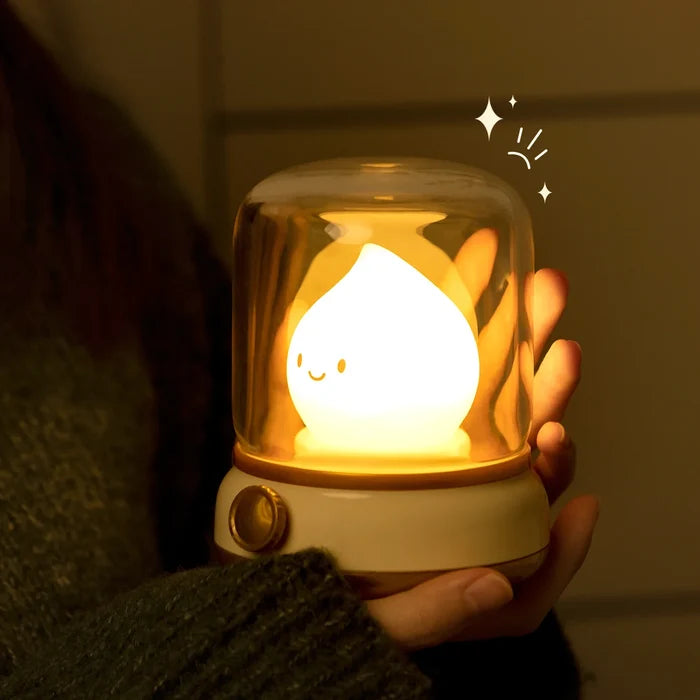 Green flame night light with glowing smiling teardrop bulb held in hand