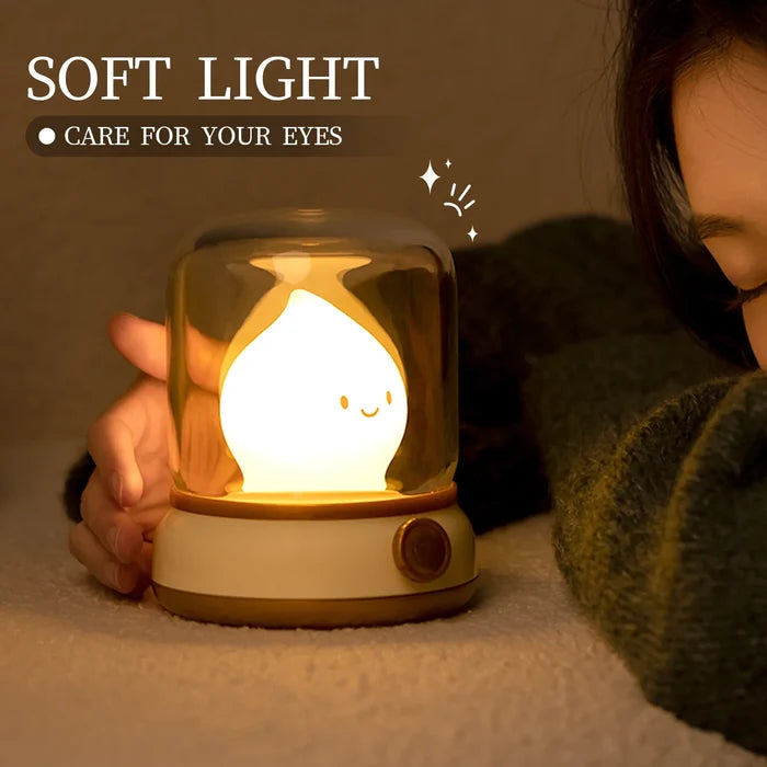 Green flame night light with glowing smiling teardrop bulb in clear glass dome